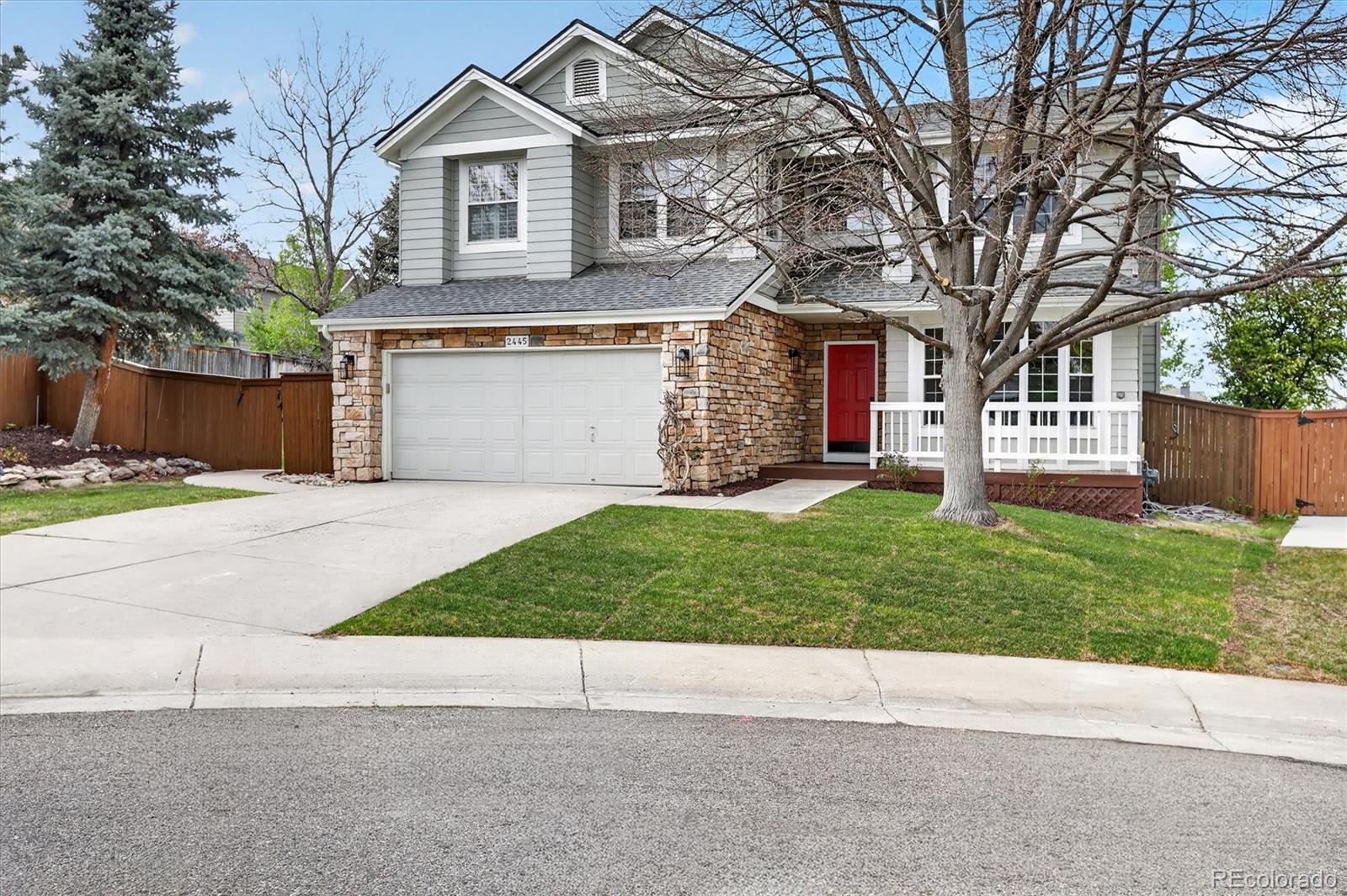 2445 East Lansdowne Court Highlands Ranch, CO 80126 - Photo 2 of 49 a front view of a house with a yard and garage