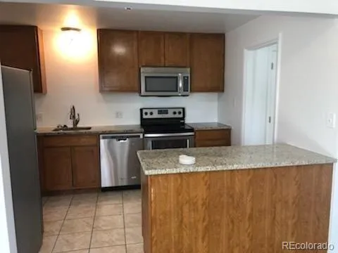 a kitchen with stainless steel appliances granite countertop a sink a stove a microwave and a refrigerator