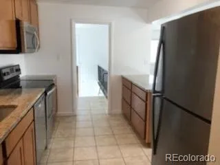 a kitchen with a refrigerator and a stove top oven