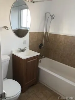 a bathroom with a sink vanity mirror and toilet