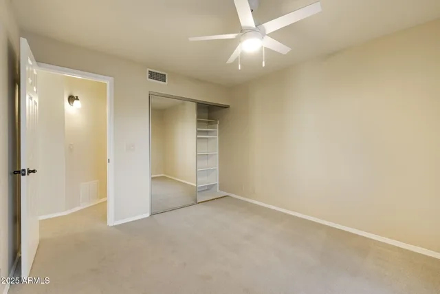 an empty room with a ceiling fan and a bathroom