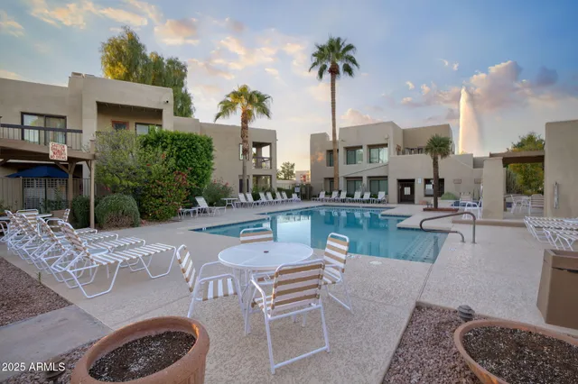 a view of a patio with couches table and chairs potted plants and palm trees