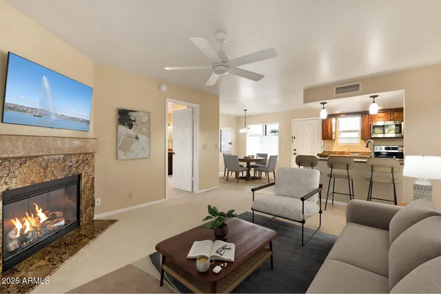 a view of empty room with kitchen and fireplace
