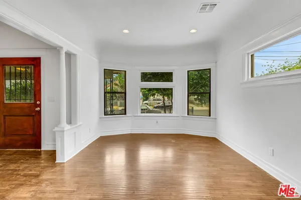 a view of empty room with wooden floor and fireplace