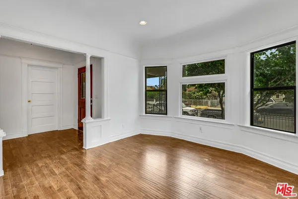 a view of empty room with a fireplace and wooden floor