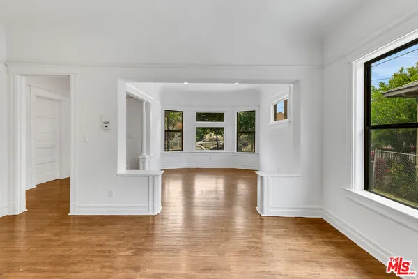 an empty room with a window and ceiling fan