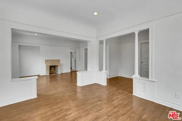 an empty room with wooden floor and fireplace