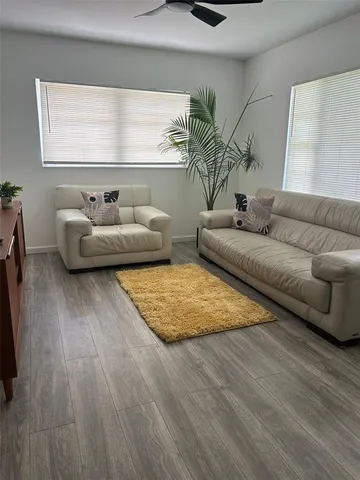 a living room with furniture and wooden floor