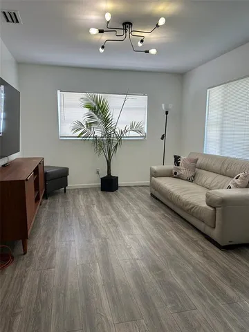 a living room with furniture and a hard wood floor