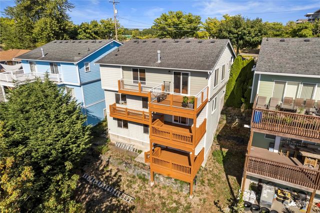 an aerial view of a house with balcony and outdoor seating