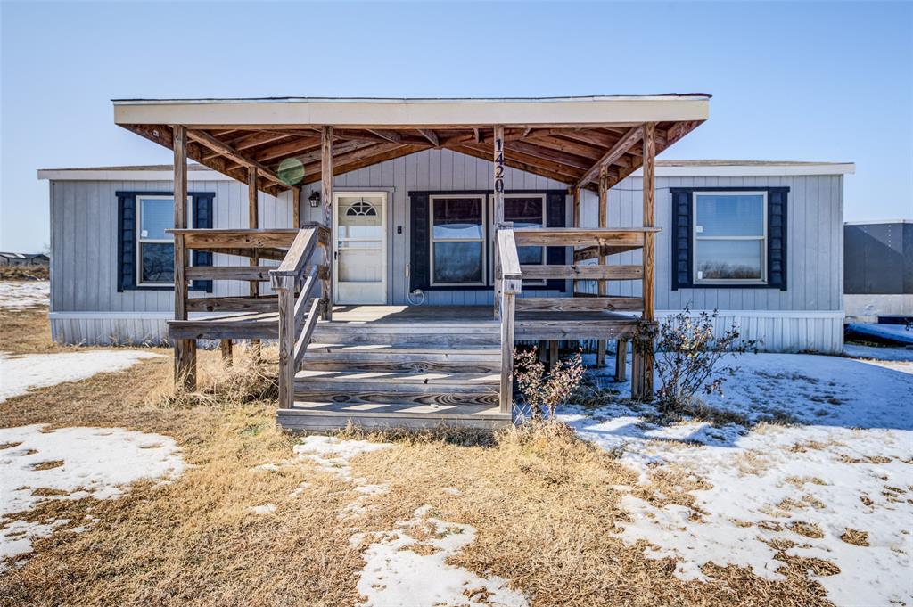 a view of a house with a patio and a yard