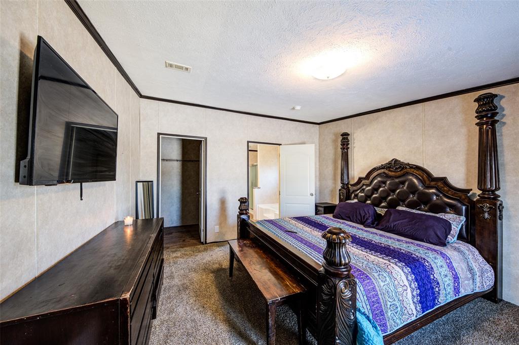 1420 County Road 4522 Decatur, TX 76234 - Photo 18 of 24 a bedroom with a bed and a flat screen tv