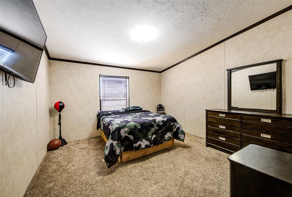 1420 County Road 4522 Decatur, TX 76234 - Photo 21 of 24 a bedroom with a bed and a flat tv screen on wall