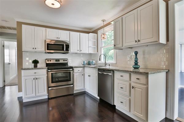 a kitchen with white cabinets and stainless steel appliances