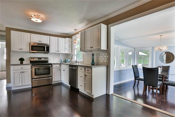 331 Pelham Street Methuen, MA 01844 - Photo 2 of 27 a kitchen with a stove a microwave a dining table and chairs