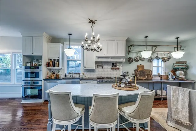 a kitchen with cabinets and chairs