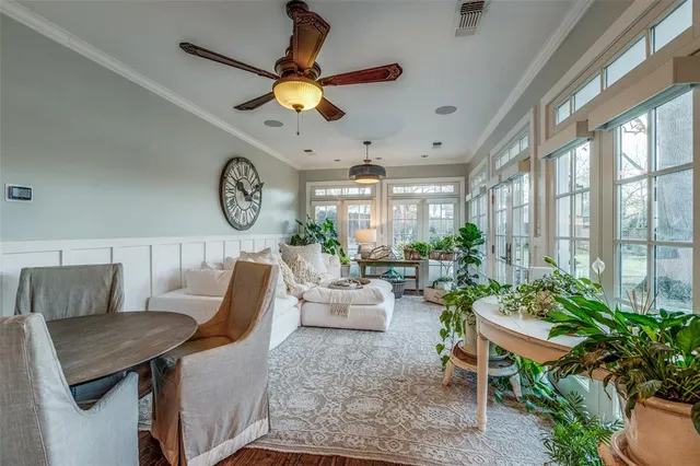 a living room with furniture a clock potted plant and a large window