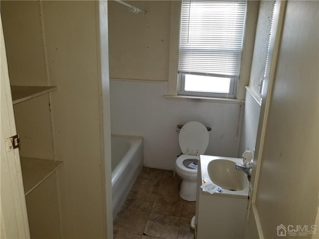 110 Rector Street Perth Amboy, NJ 08861 - Photo 11 of 15 a white toilet sitting in a bathroom next to a window