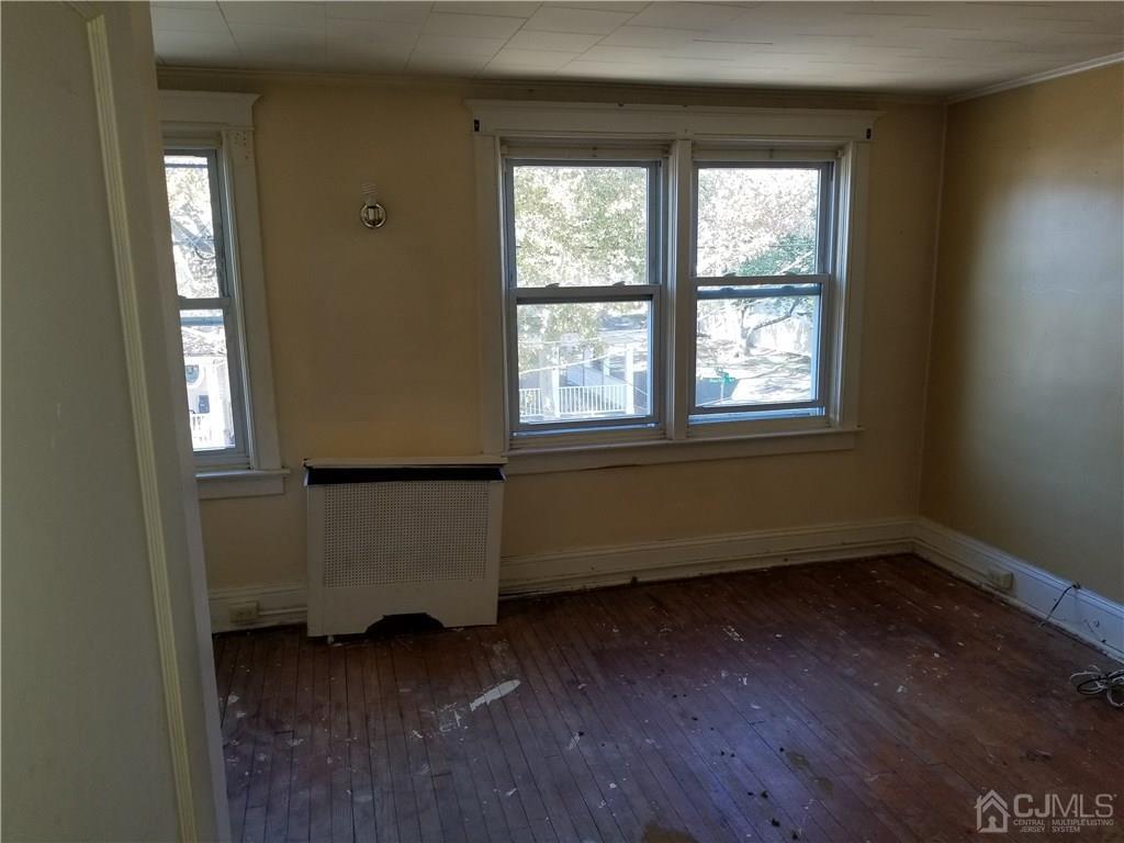 110 Rector Street Perth Amboy, NJ 08861 - Photo 12 of 15 an empty room with wooden floor and windows