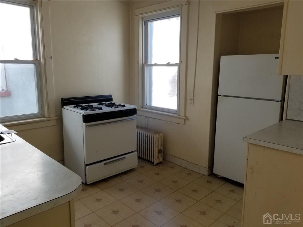 110 Rector Street Perth Amboy, NJ 08861 - Photo 13 of 15 a kitchen with a stove a refrigerator and a window