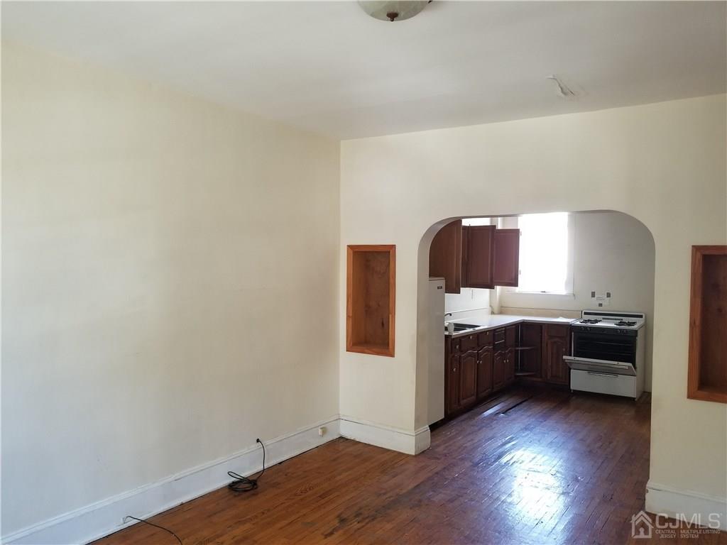 110 Rector Street Perth Amboy, NJ 08861 - Photo 4 of 15 a kitchen with wooden floors and appliances