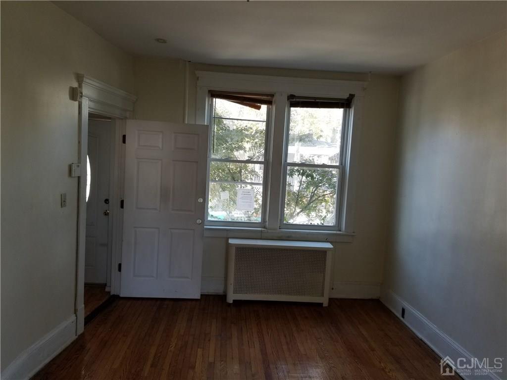 110 Rector Street Perth Amboy, NJ 08861 - Photo 6 of 15 an empty room with wooden floor and windows