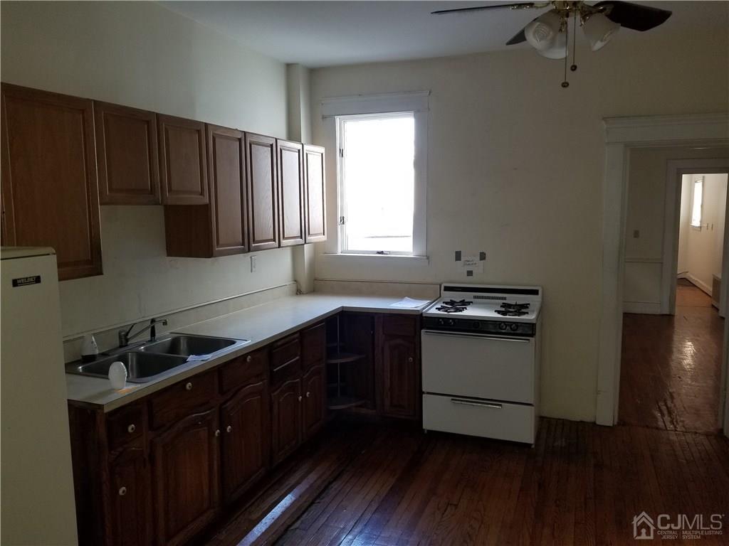 110 Rector Street Perth Amboy, NJ 08861 - Photo 7 of 15 a kitchen with granite countertop a sink a stove a refrigerator and cabinets