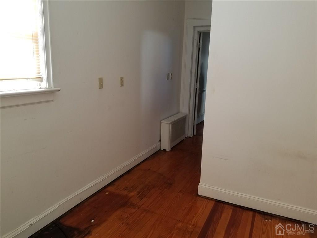 110 Rector Street Perth Amboy, NJ 08861 - Photo 10 of 15 a view of an empty room with wooden floor and a window