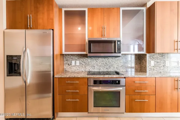 a kitchen with stainless steel appliances granite countertop a refrigerator stove and microwave