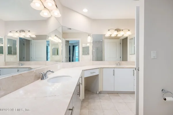 a spacious bathroom with a granite countertop sink a mirror and a bathtub