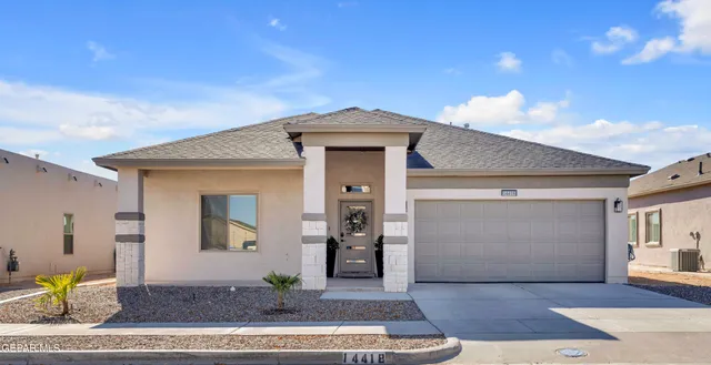 a front view of a house with glass windows and yard