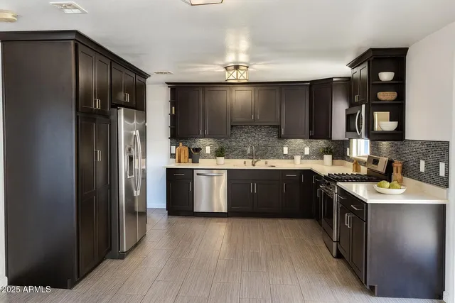 a kitchen with stainless steel appliances a sink stove and refrigerator