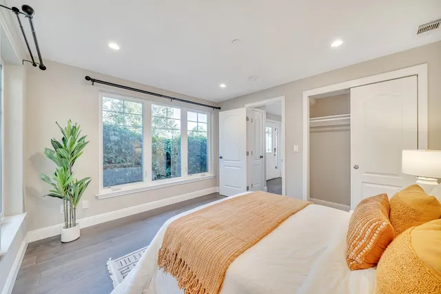 a bedroom with a large bed and a potted plant