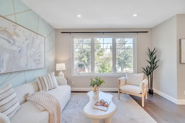 a living room with furniture and a large window with garden view