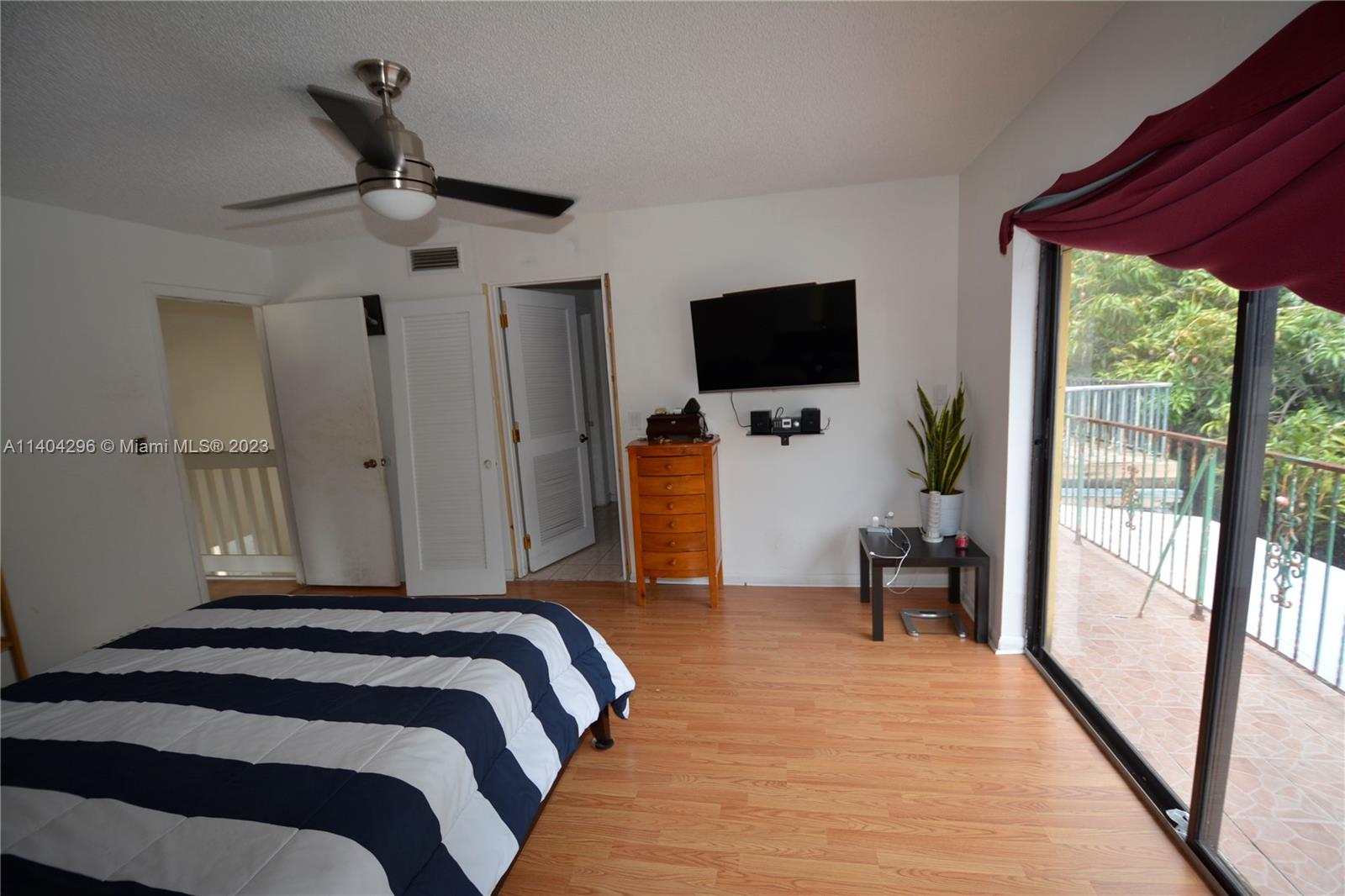 10915 Southwest 25th Street, Unit 2 Miami, FL 33165 - Photo 21 of 28 a bedroom with a bed and a flat tv screen on the dresser