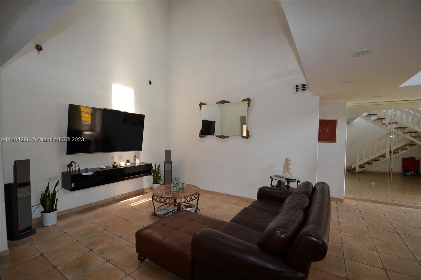 10915 Southwest 25th Street, Unit 2 Miami, FL 33165 - Photo 3 of 28 a living room with furniture and a flat screen tv