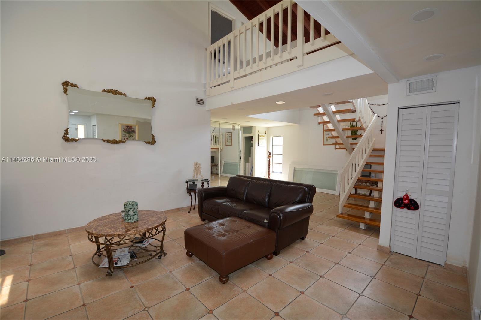 10915 Southwest 25th Street, Unit 2 Miami, FL 33165 - Photo 4 of 28 a living room with furniture and stairs