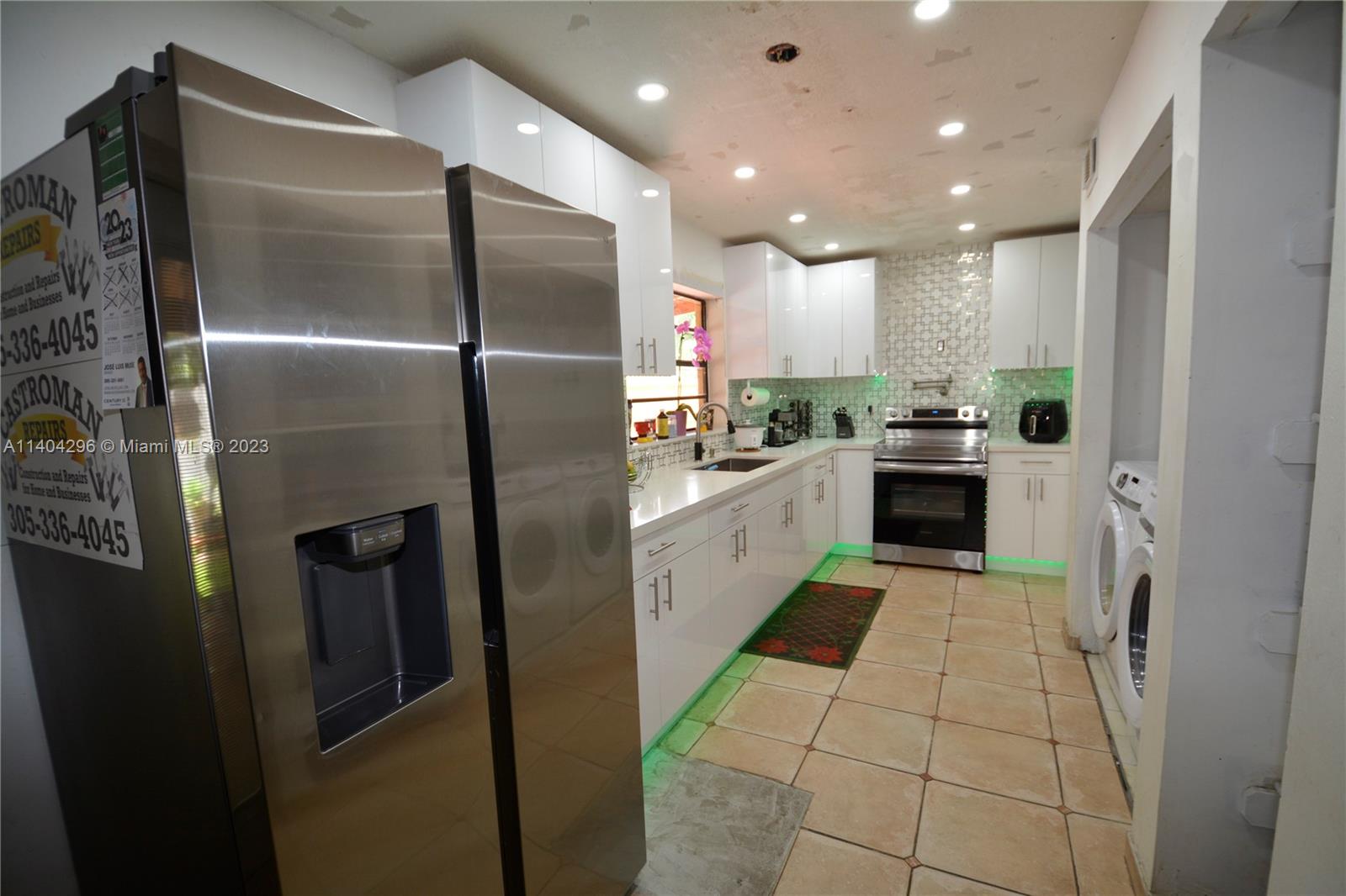 10915 Southwest 25th Street, Unit 2 Miami, FL 33165 - Photo 8 of 28 a large kitchen with stainless steel appliances kitchen island granite countertop a refrigerator and a sink
