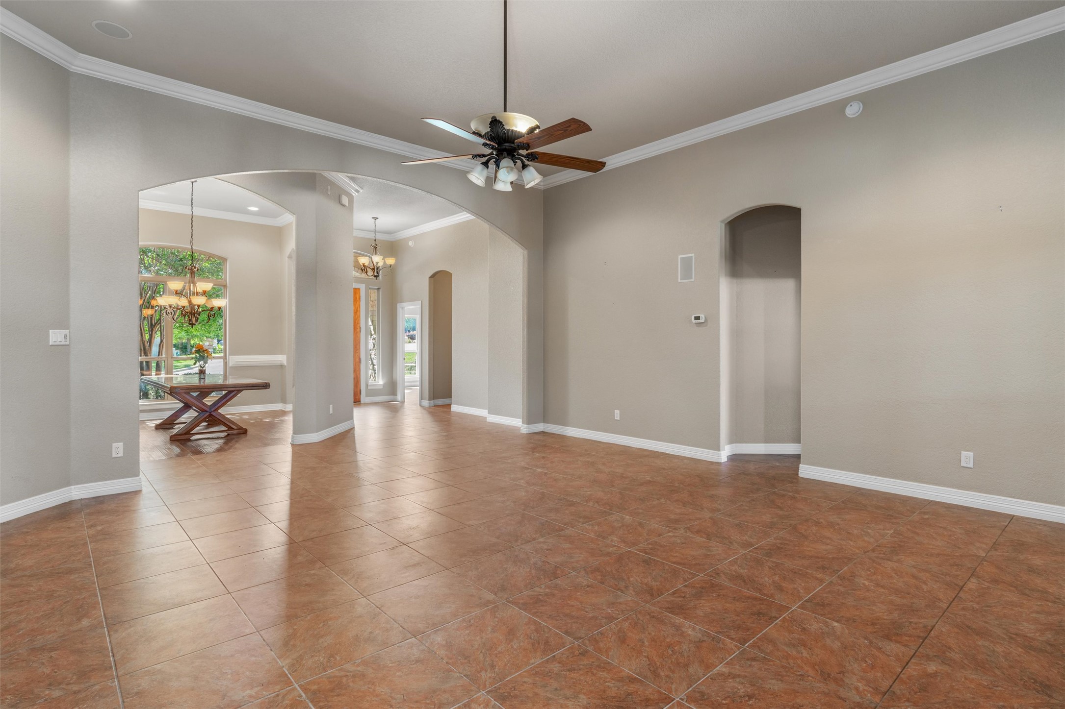 8006 Ridgeway Court Nolanville, TX 76559 - Photo 11 of 40 Spare room with a ceiling fan, crown molding, dark tile patterned floors, and a chandelier