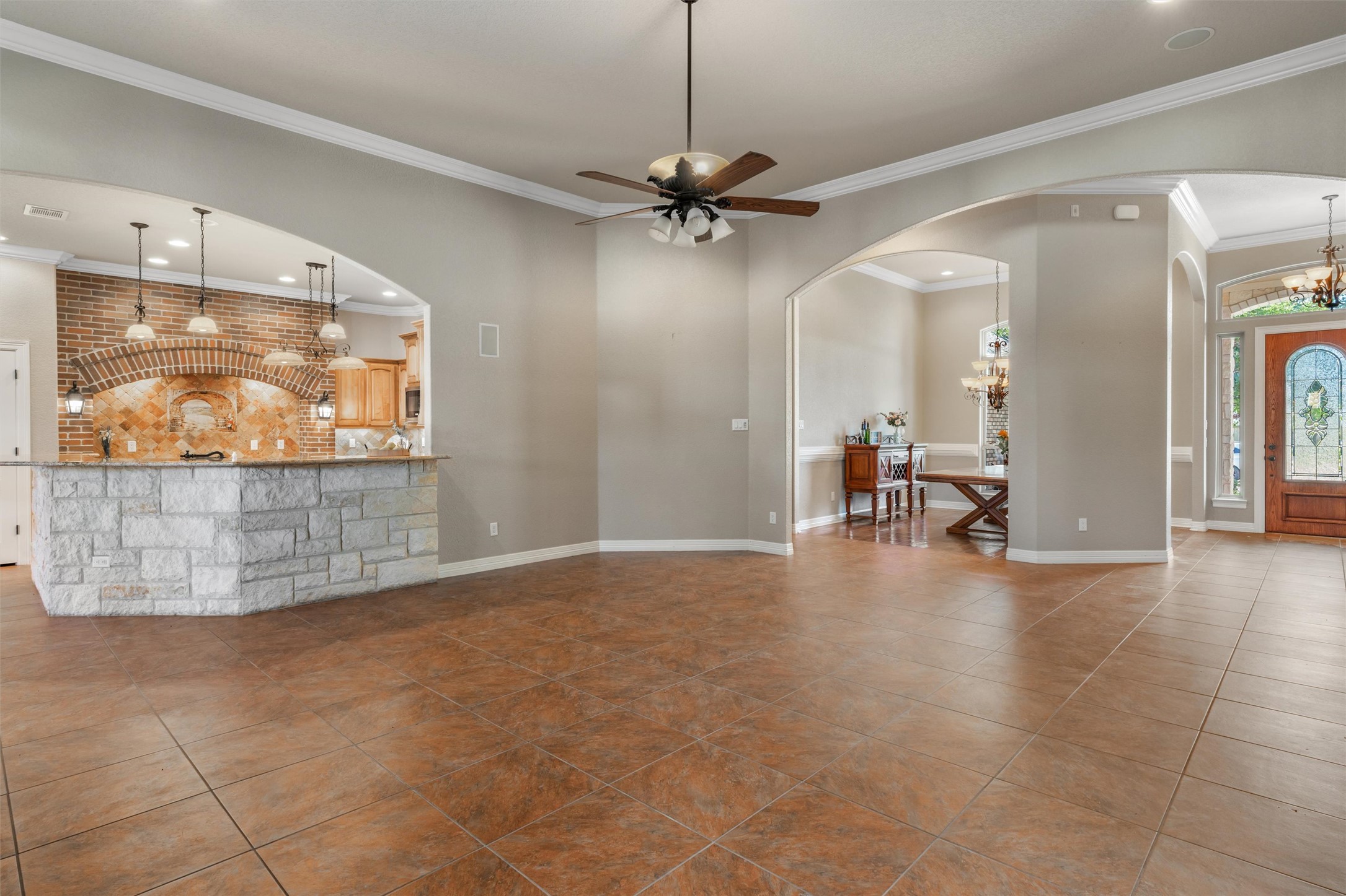 8006 Ridgeway Court Nolanville, TX 76559 - Photo 12 of 40 Living area featuring a ceiling fan, ornamental molding, tile patterned flooring, arched walkways, and a chandelier