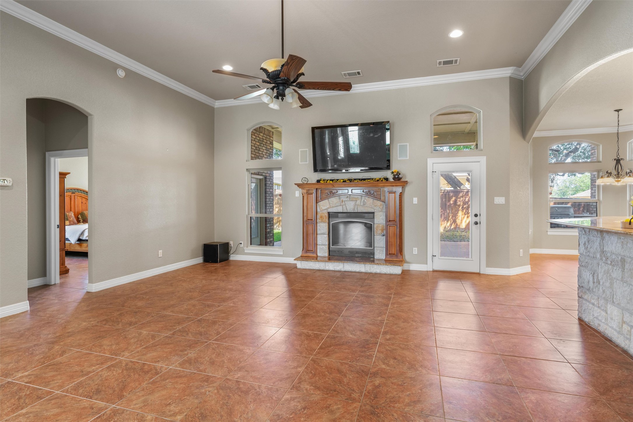 8006 Ridgeway Court Nolanville, TX 76559 - Photo 13 of 40 Unfurnished living room featuring arched walkways, a ceiling fan, crown molding, a fireplace, and light tile patterned floors
