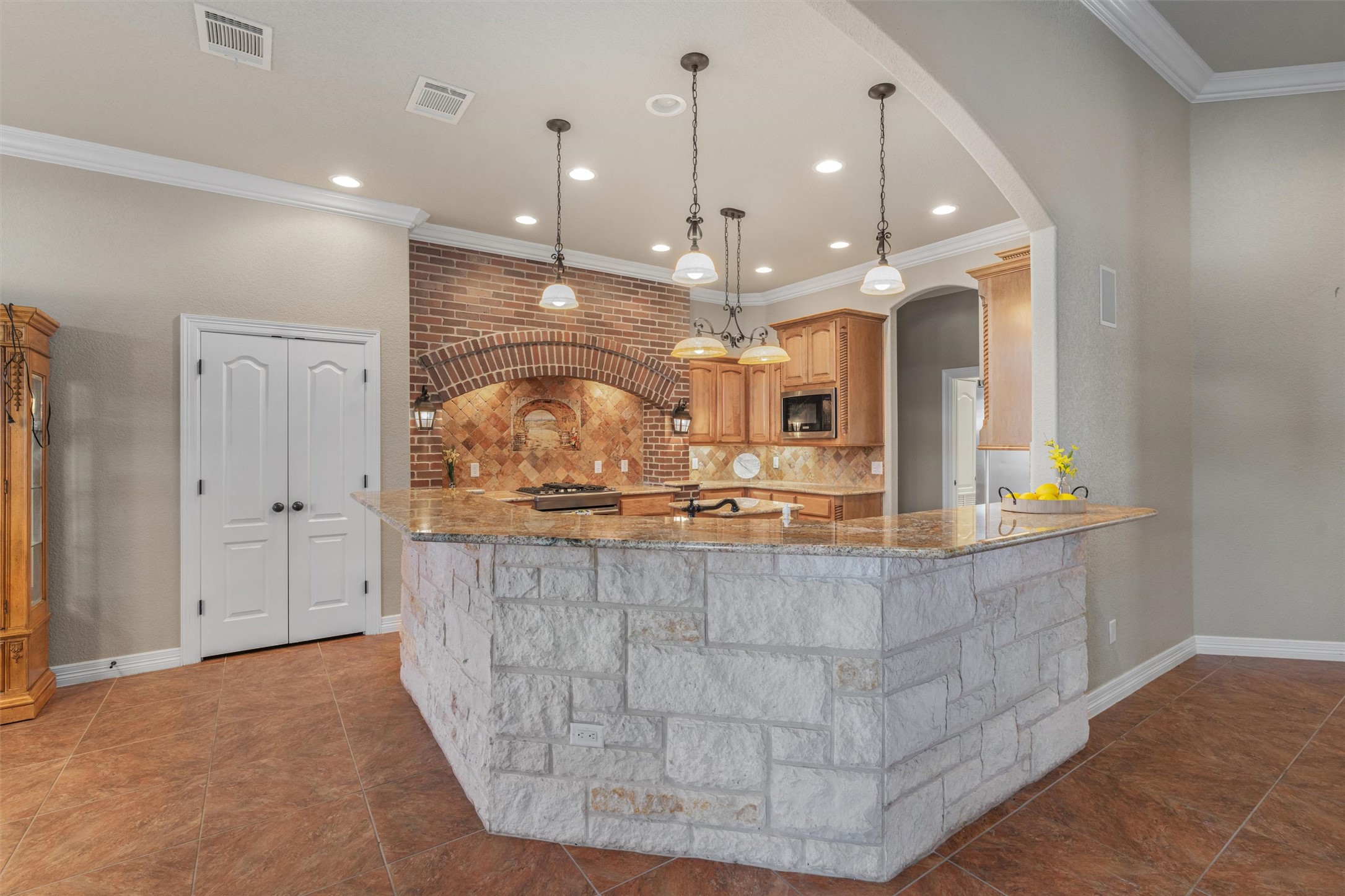 8006 Ridgeway Court Nolanville, TX 76559 - Photo 14 of 40 Kitchen featuring light stone countertops, ornamental molding, a peninsula, hanging light fixtures, and stainless steel appliances