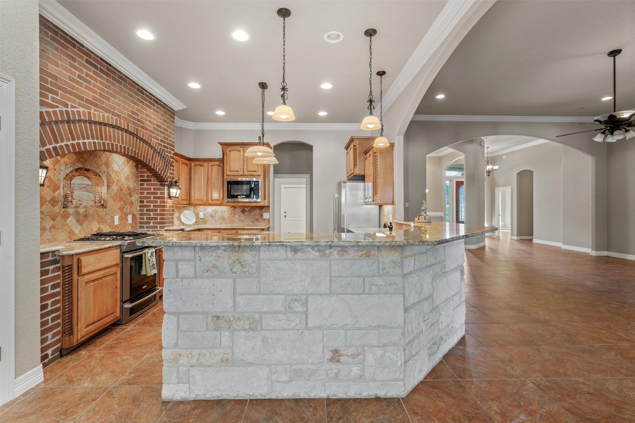 8006 Ridgeway Court Nolanville, TX 76559 - Photo 17 of 40 Kitchen with light stone counters, arched walkways, ornamental molding, tasteful backsplash, and stainless steel appliances