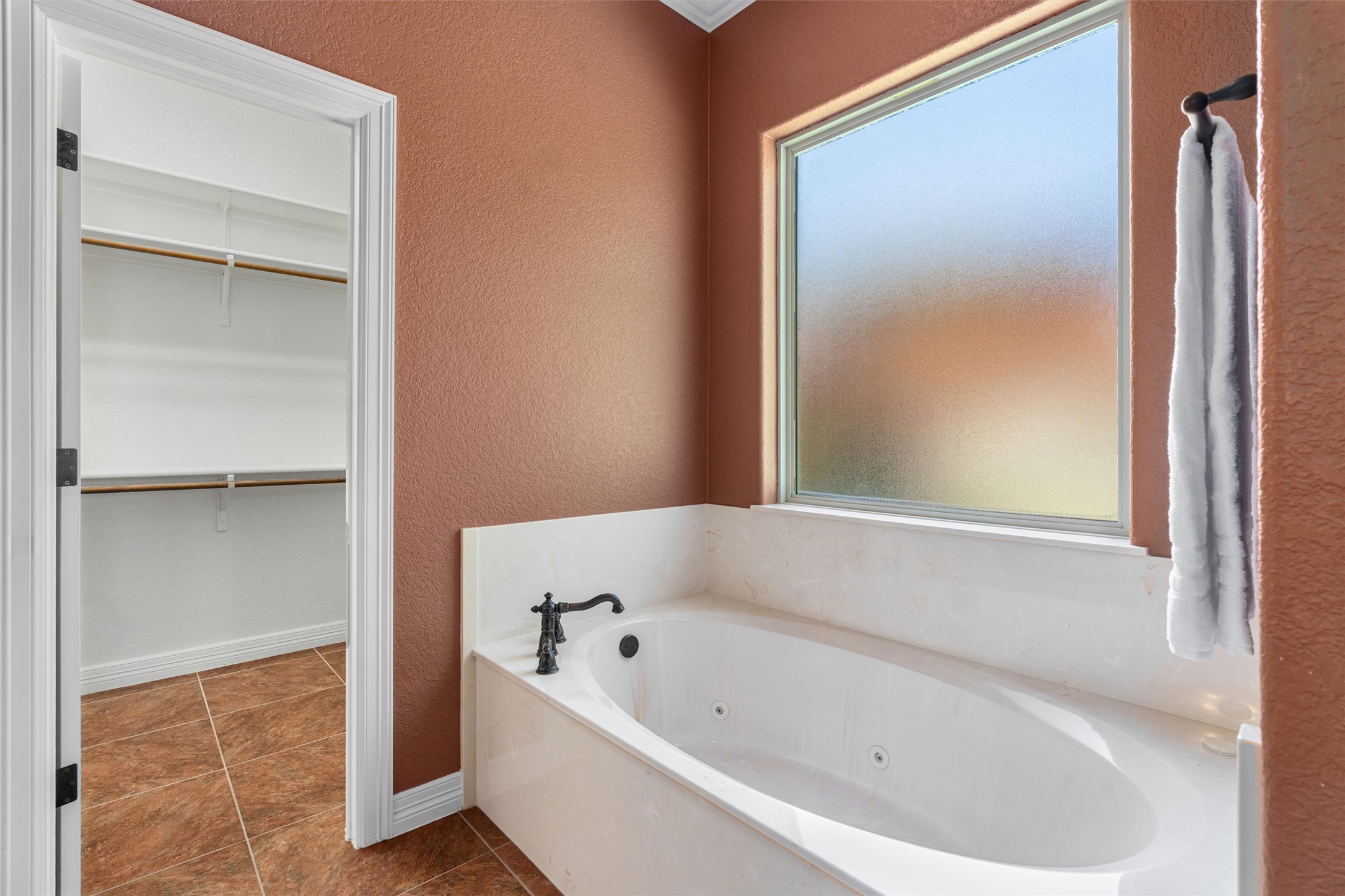 8006 Ridgeway Court Nolanville, TX 76559 - Photo 26 of 40 Bathroom featuring a textured wall, a jetted tub, a spacious closet, and dark tile patterned floors
