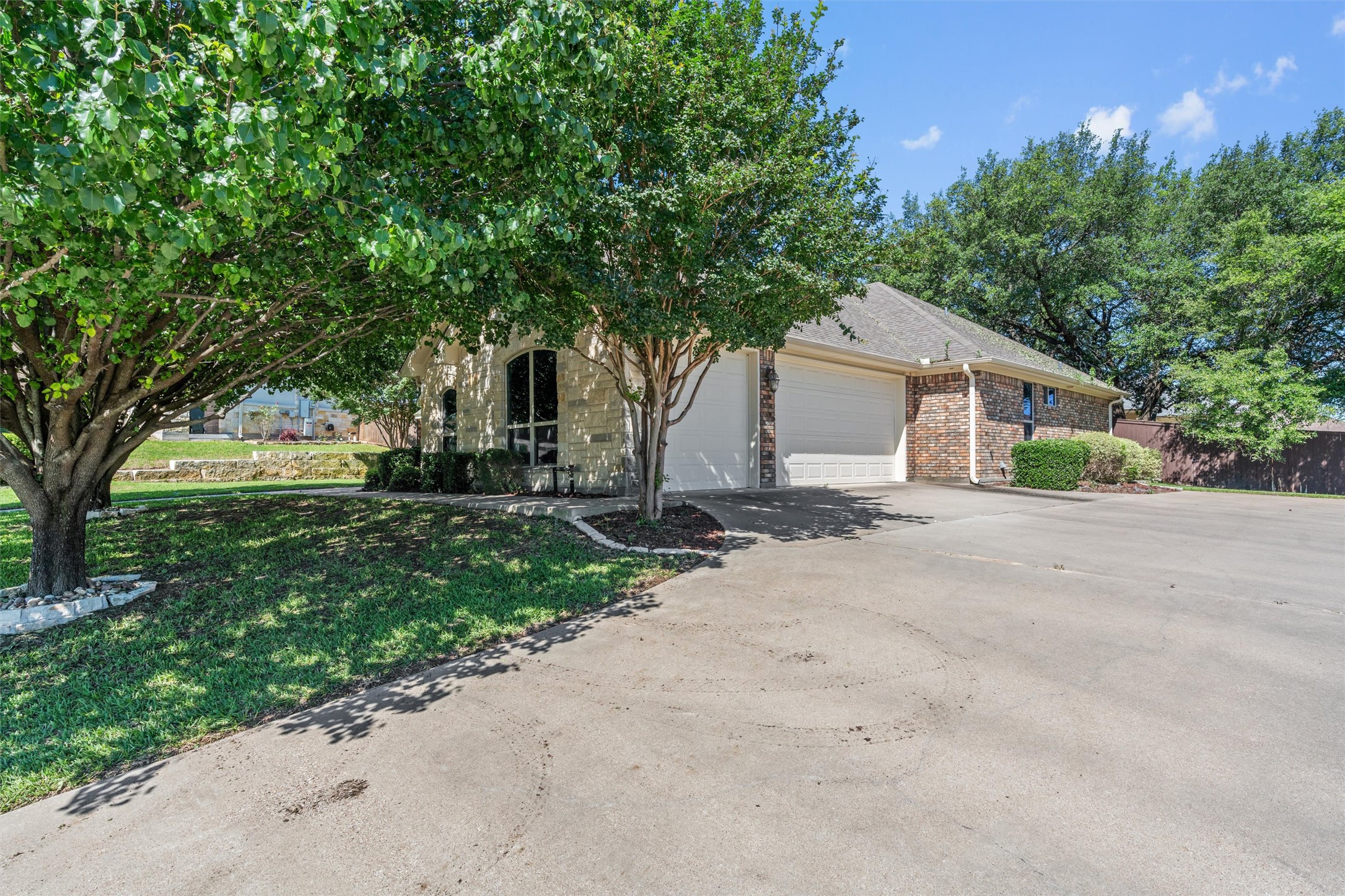8006 Ridgeway Court Nolanville, TX 76559 - Photo 4 of 40 View of property hidden behind natural elements with a garage, driveway, a front yard, and brick siding