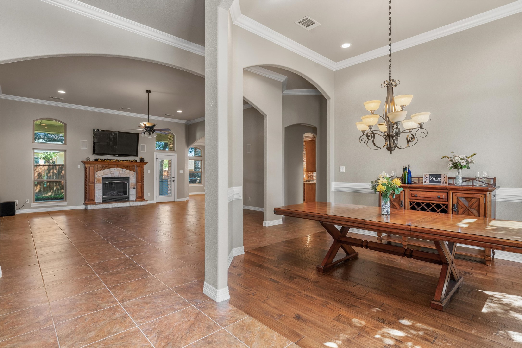 8006 Ridgeway Court Nolanville, TX 76559 - Photo 6 of 40 Dining area with a chandelier, ornamental molding, wood-type flooring, a fireplace, and a ceiling fan