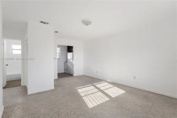 an empty room with windows and closet