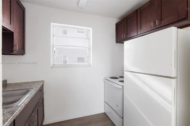 a kitchen with a refrigerator sink and cabinets
