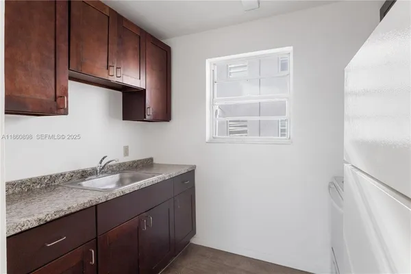 a kitchen with granite countertop cabinets stainless steel appliances a sink and a window