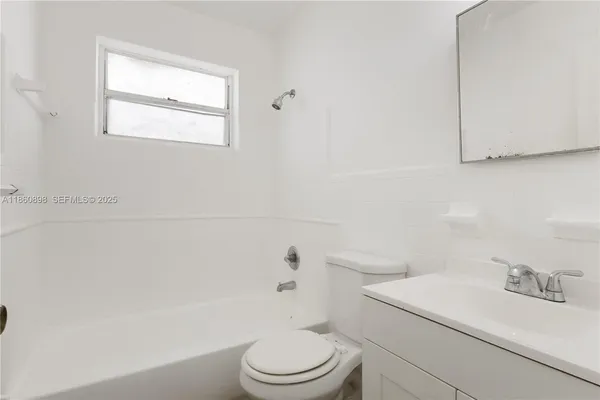 a white toilet sitting next to a bath tub